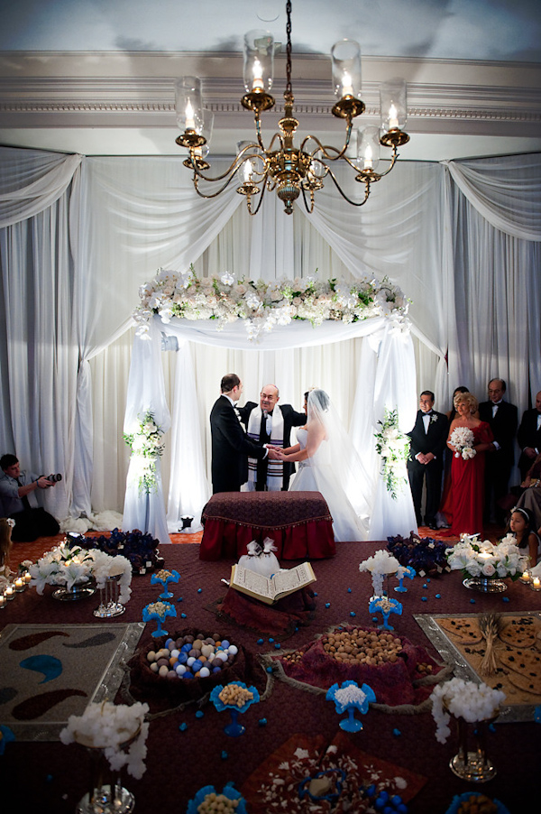 the bride and groom exchanging vows under a chuppah during a traditional Jewish ceremony - photo by Houston based wedding photographer Adam Nyholt 